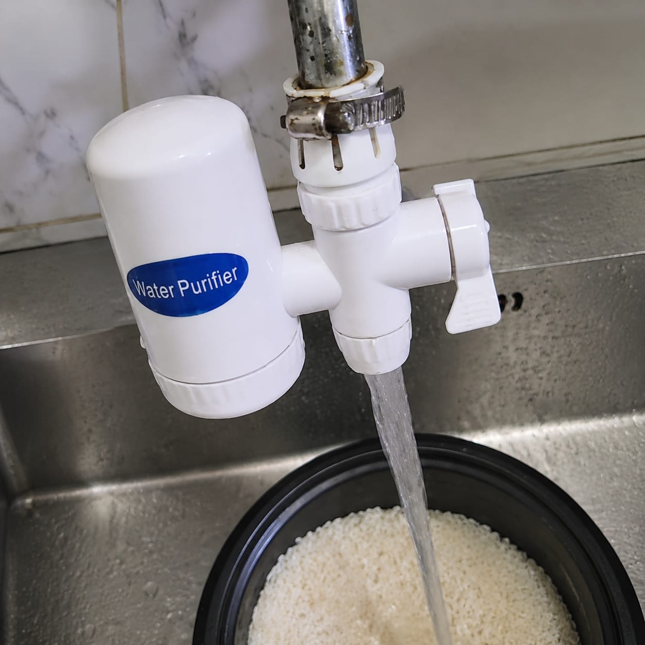 SWS purifier fixed on the kitchen tap, washing rice with clean filtered water